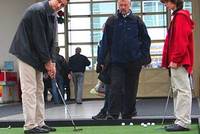 Golfisté si hrají na umělém trávníku v hale