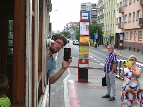 Historická tramvaj a mobilní telefon.