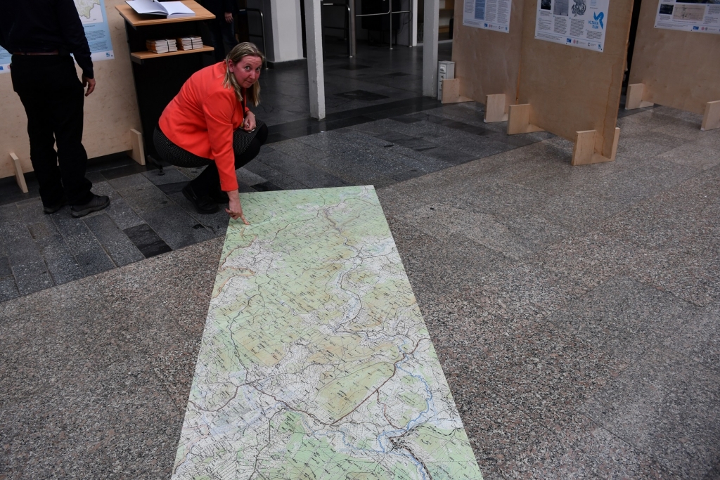 Dana Fialová hlavní řešitelka programu o Vltavě z Přírodovědecké fakulty UK na mapovém koberci ukazuje místo, kde najdete na mapě pramen Vltavy.