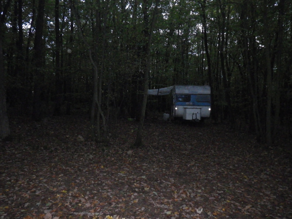 Zaparkovaný karavan uprostřed lesa u Karlštejna.