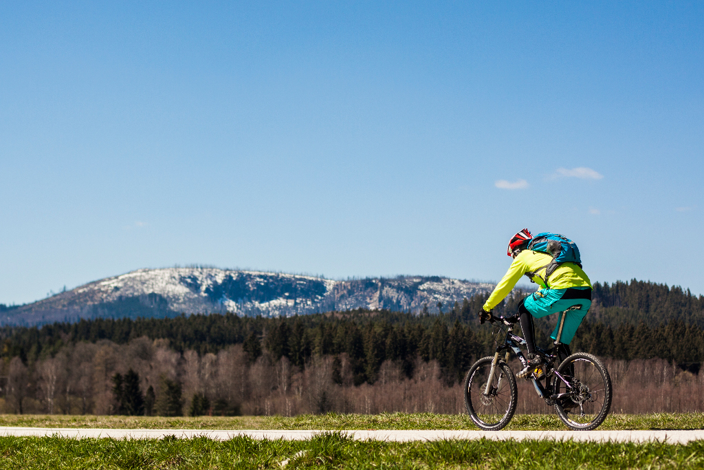 Lipno. Když leží sníh jen na vrcholcích hor, jezdí se na kole po cyklostezce.