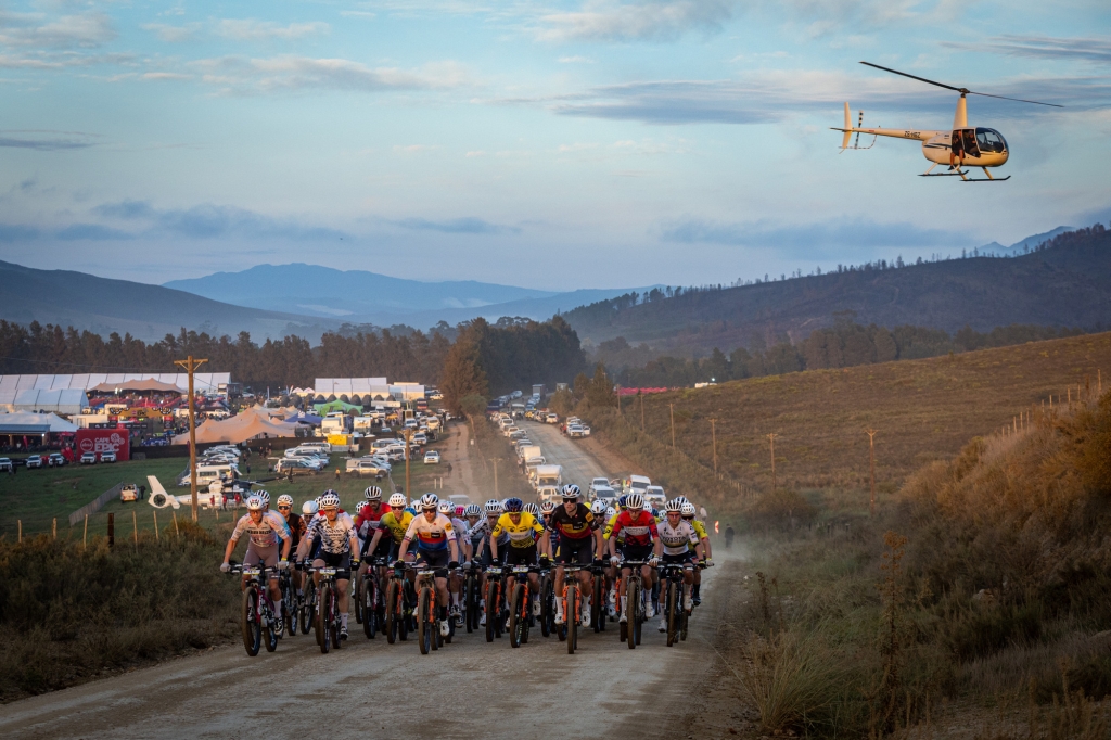 Peloton horských cyklistů jede na silnici.