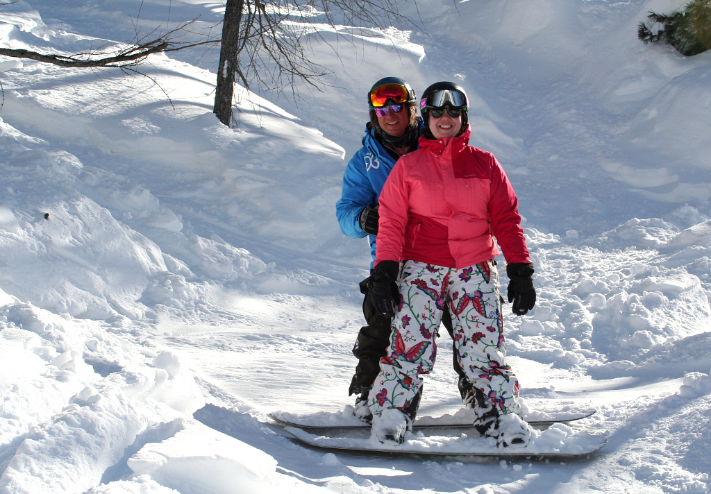 Marilleva. Australanka se učí v Itálii jezdit na snowboardu s pomocí najatého instruktora.