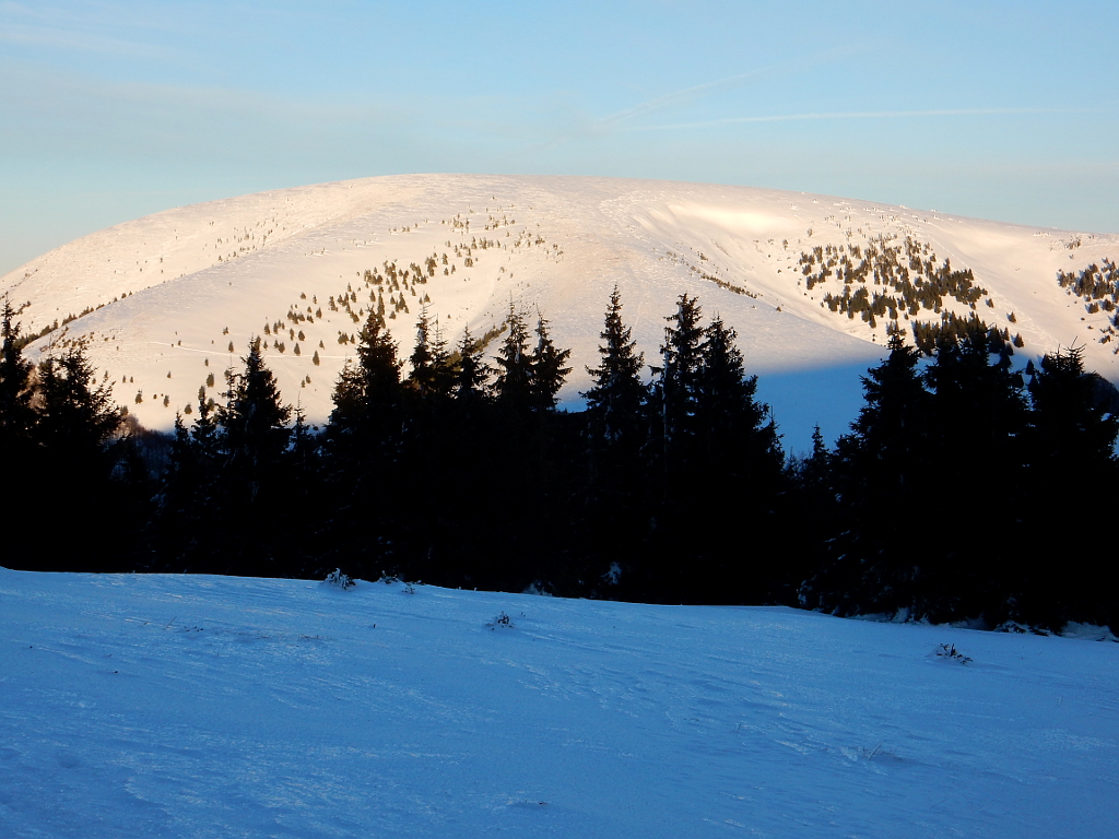 Ploská (1532 m) v zapadajícím slunci. Vlevo se svažuje k Borišovu, vpravo spadá do Zelené doliny.