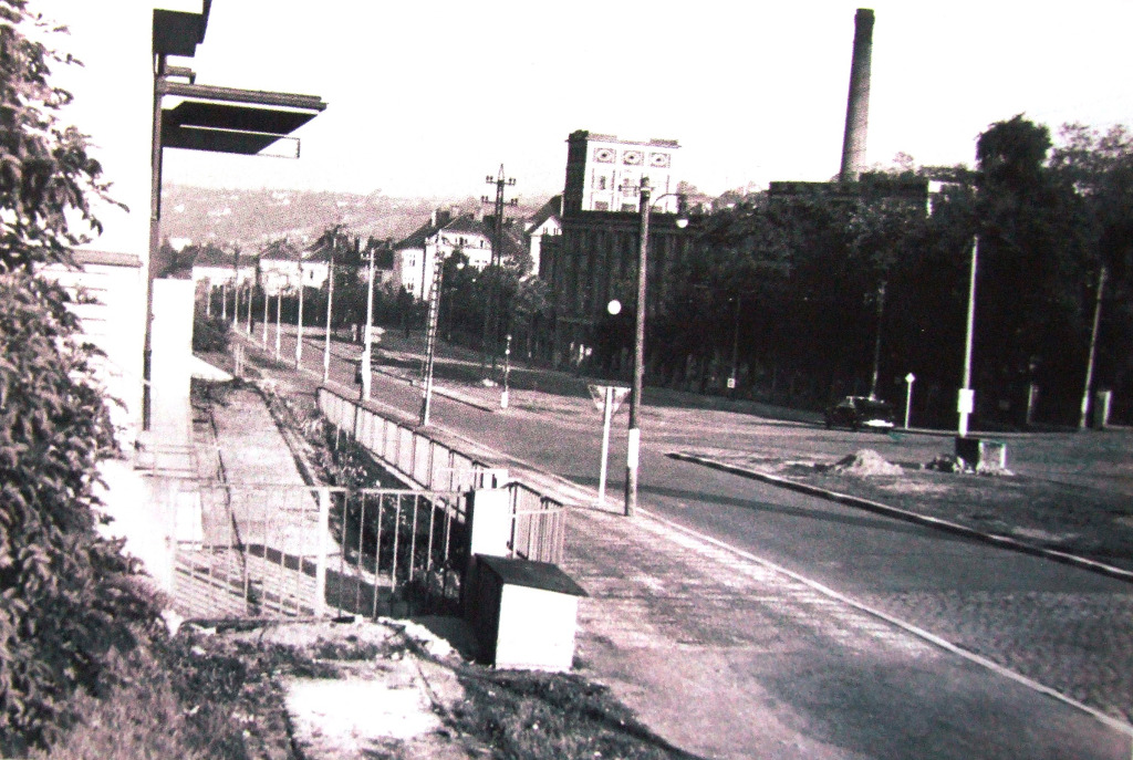 Ulice v Holešovičkách. Pohled směrem na jih ke Trojského mostu. Trafačka vlevo a budova s komínem vlevo zůstaly původní.
