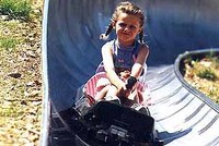 Kovovými tobogany se řítí vozíky na kolečkách  Kovovými tobogany se řítí vozíky na kolečkách