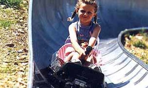 Kovovými tobogany se řítí vozíky na kolečkách  Kovovými tobogany se řítí vozíky na kolečkách