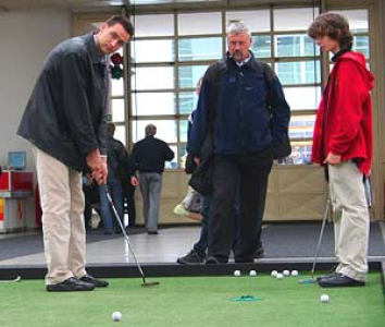 Golfisté si hrají na umělém trávníku v hale