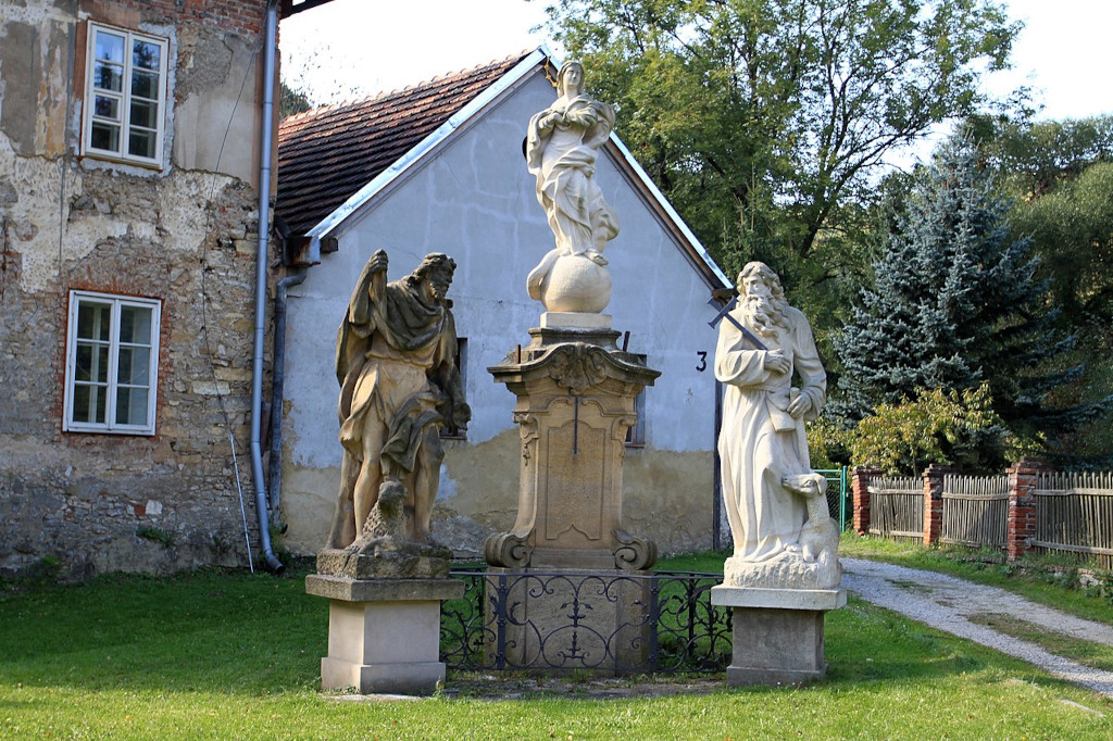 Barokní sousoší ve Svatém Janu pod Skálou: Panna Marie, Jan Křtitel s křížem a svatý Ivan s laní u nohou.