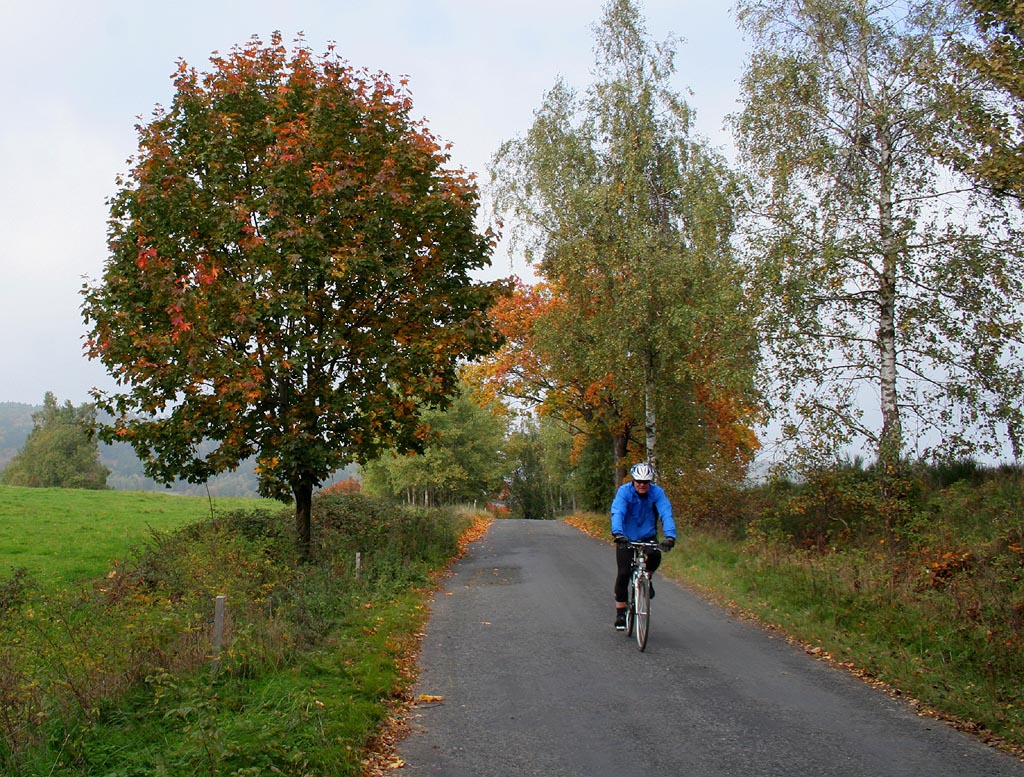 Cyklista jede podzimní přírodou nad Krompachem.