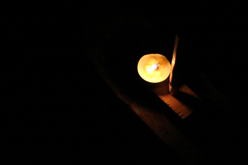 Hořící svíčka na dřevěné loďce.