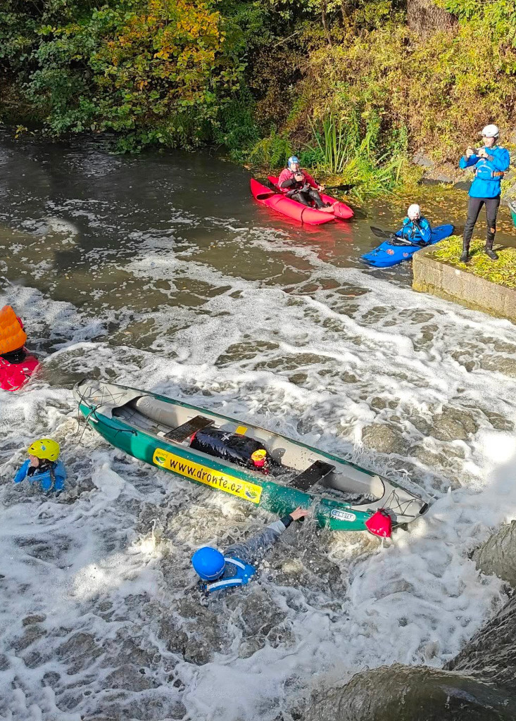 Posádka nedobrovolně opustila kanoi a kajakář odjíždí po proudu. Kanoe se pokouší sestřelit kajak. Botič, jez Marcela.