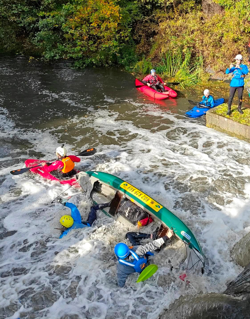 Kajak ujíždí kanoi. Botič, jez Marcela.