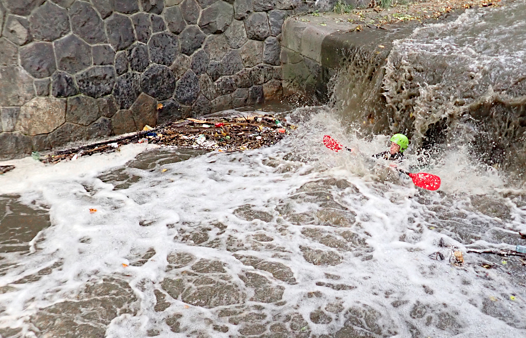 Kajakář se vynořuje pod stupněm Grébovka, Botič.