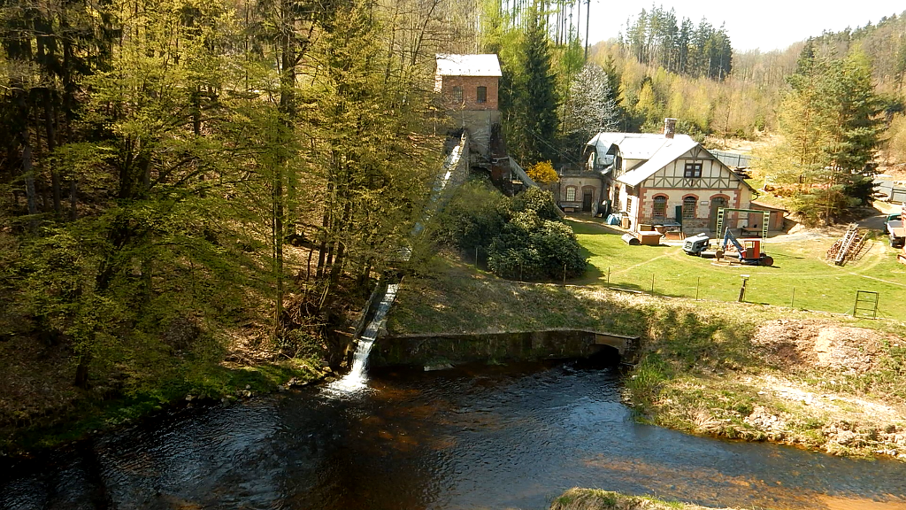 Vodní elektrárna Frýdlant na Smědé pod skalnatým hřbetem Harta.
