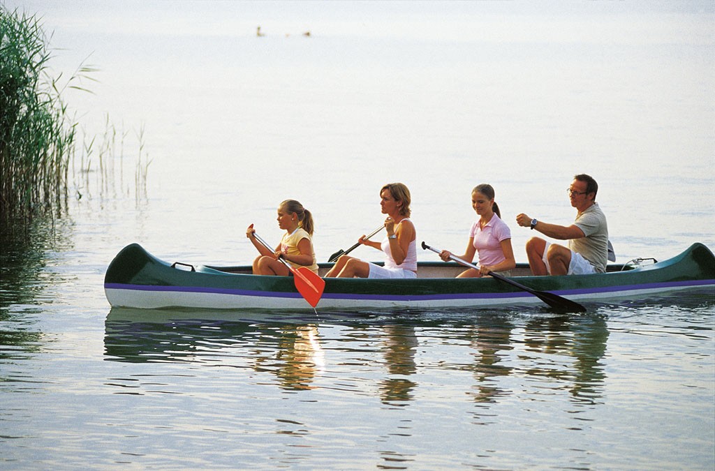 Rodinná kanoe pluje na velké řece.
