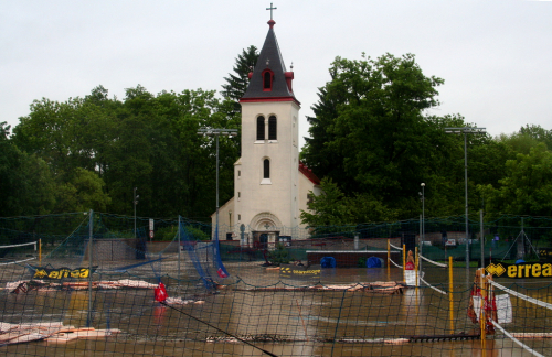 Kostel Panny Marie u Hamerského rybníku shlíží na zničené volejbalové hřiště.