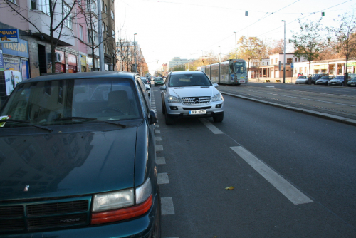 Cyklopruh na Vinohradské ulici v Praze blokuje Mercedes.