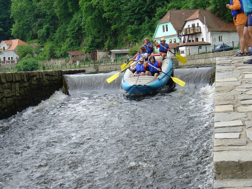 Raft sjíždí jez na Vltavě.