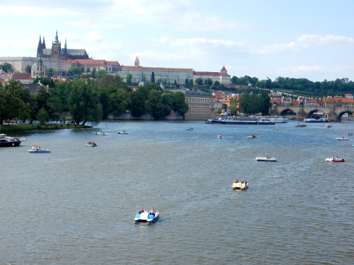 Vltava, Hradčany. Karlův most a lodičky na řece.