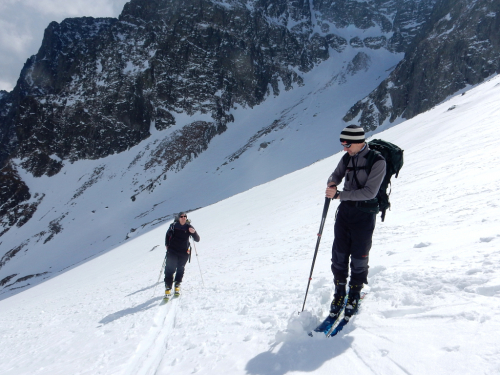 Petr a David na lyžích stoupají Veľkou Zmrzlou dolinou.