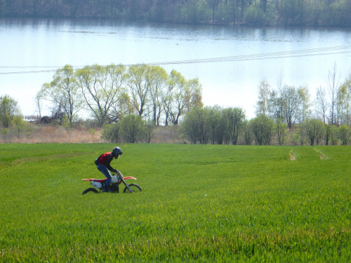 Motorkář jede po poli nad přehradou Niedow na řece Smědá / Witka.